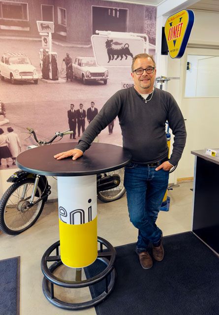 Heikki Mäkinen myymälässä nojaamassa pöytään.