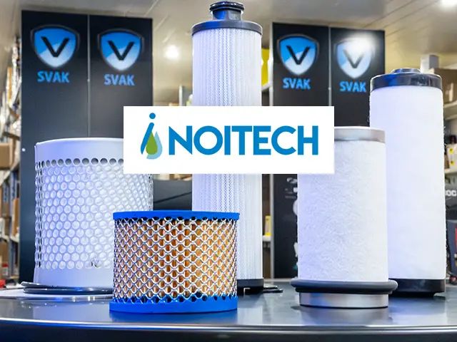 Viisi Noitechin suodatinta rivissä myymälän pöydällä, taustalla hyllyissä Suomen Voiteluainekaupan logoja. Kuvan keskellä Noitechin logo.
